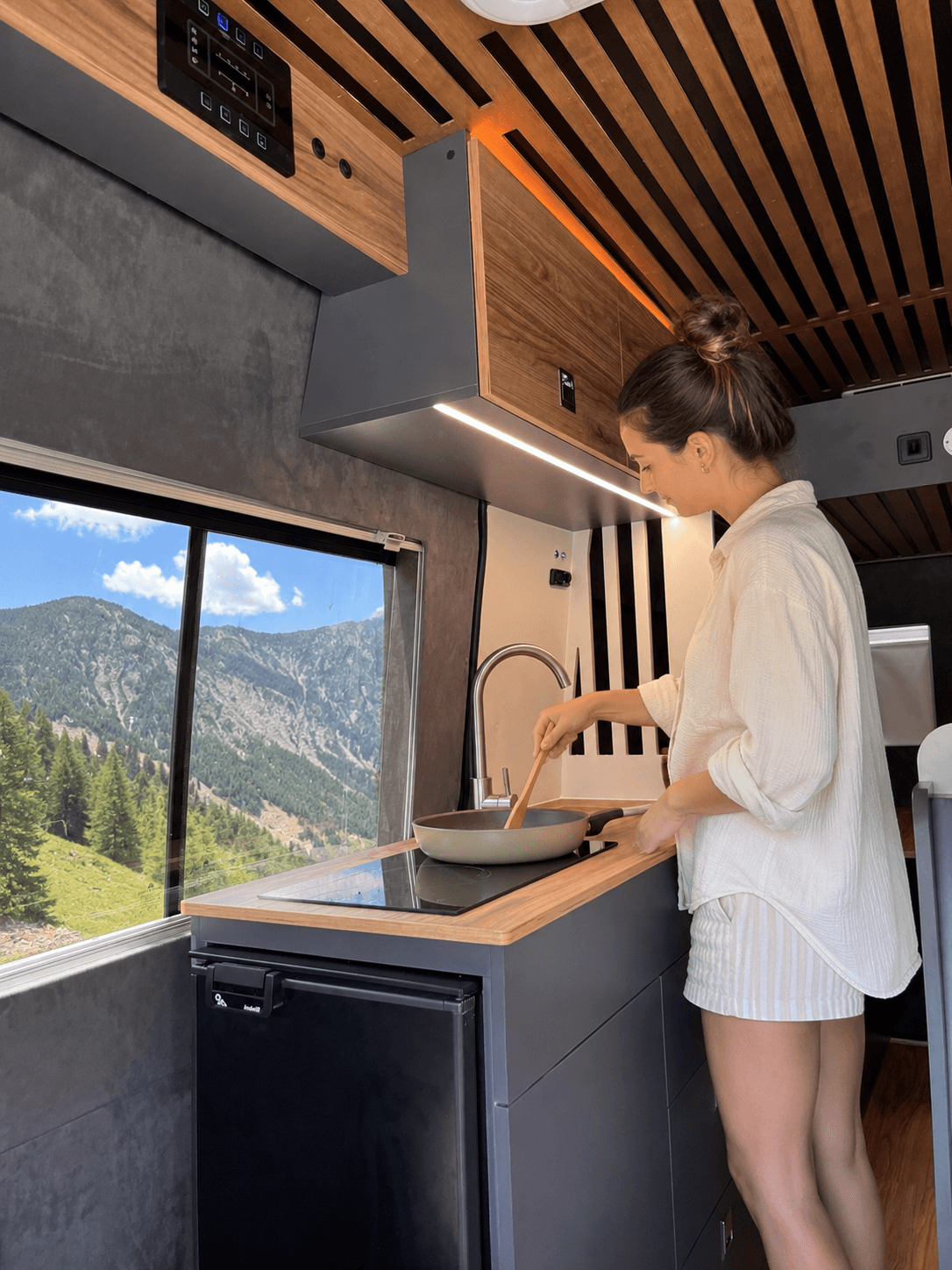 Persona utilizando la cocina interior de un vehículo MUNDUA